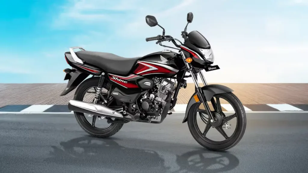 Honda Shine 100 DX 2025 in motion with rider wearing helmet, city background